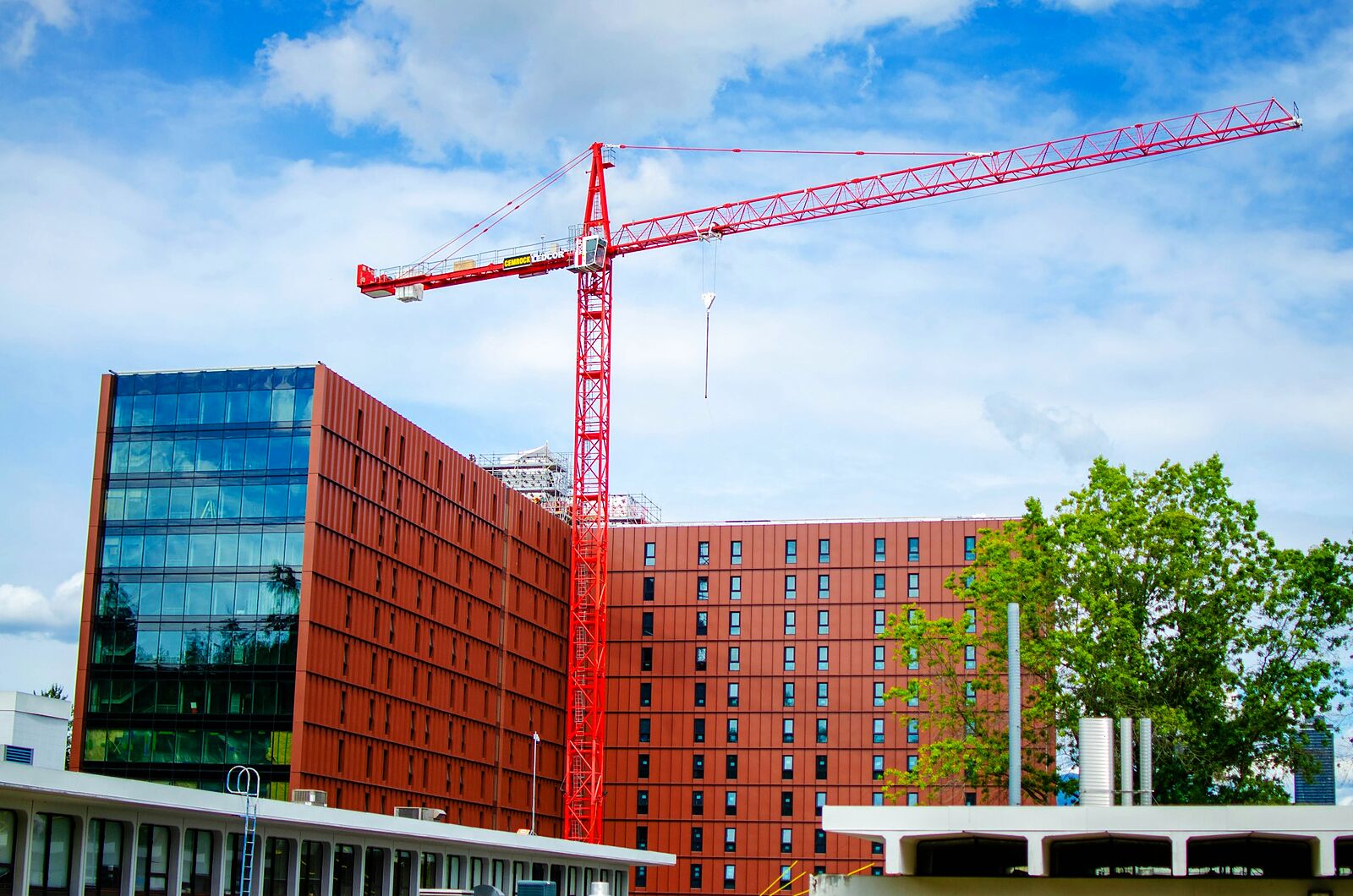 Un immeuble en construction et sa grue, sous un ciel bleu.